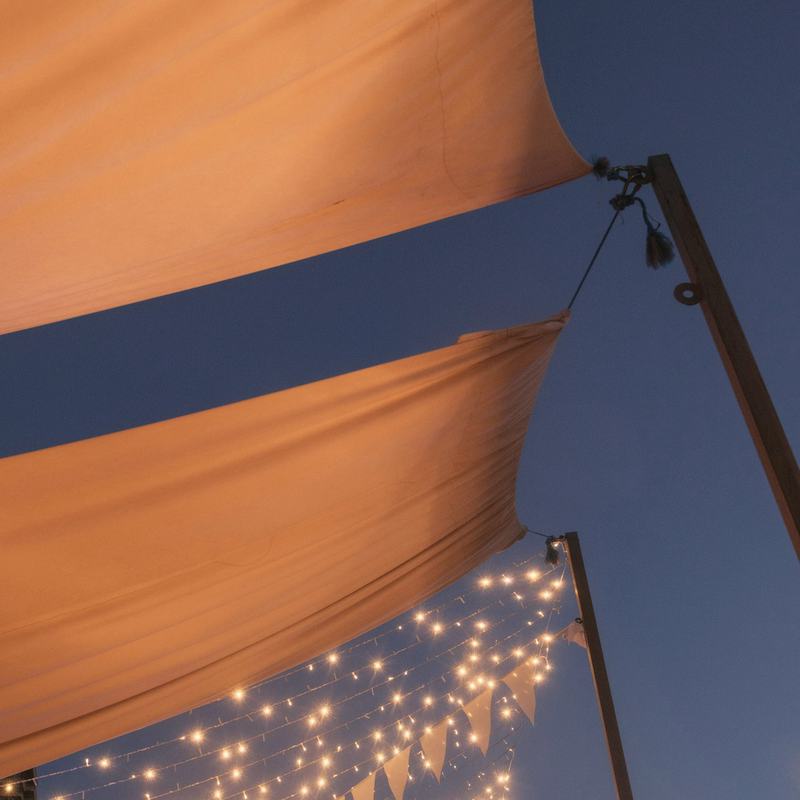 Sonnensegel mit Lichterketten zur blauen Stunde